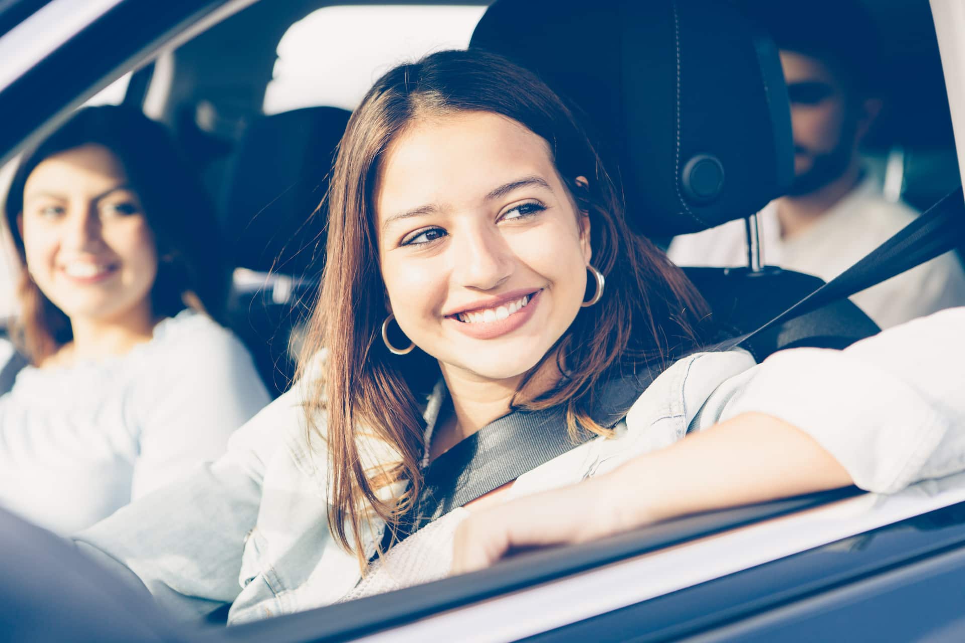 Femme souriante au volant de sa voiture